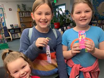 Students make bookmarks after listening to a story. 